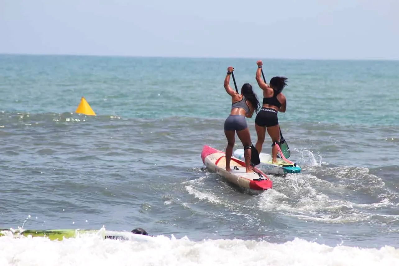 Natalí Elisei remando junto a otra atleta hacia las olas